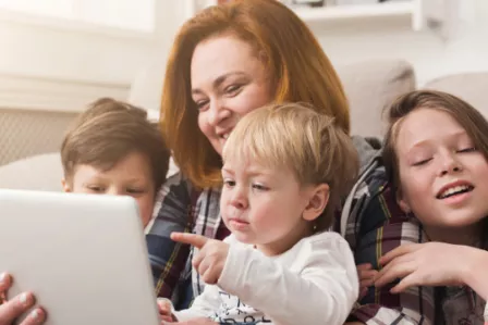 Family gathered around a tablet device