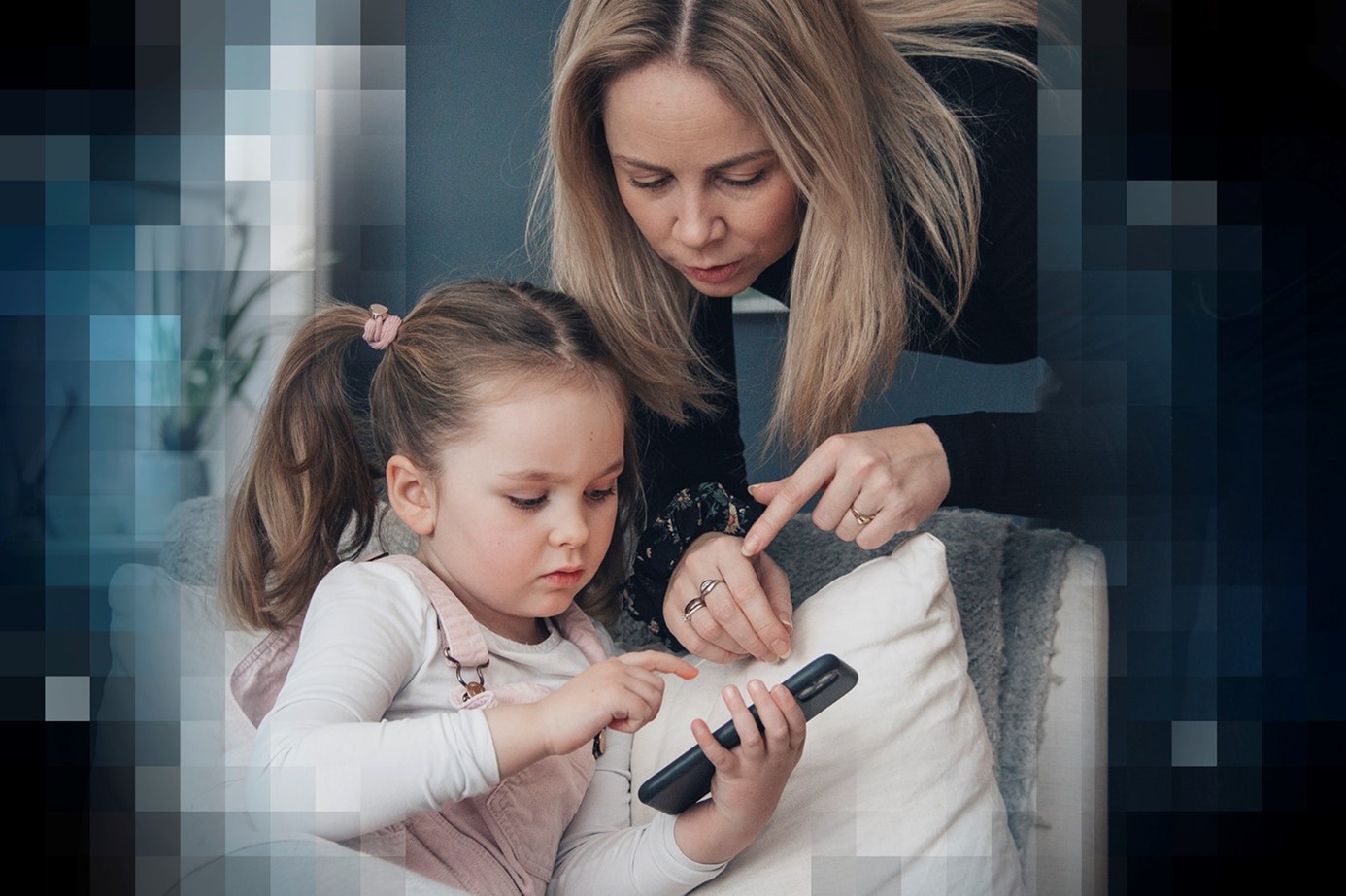 adult and child looking at mobile device together