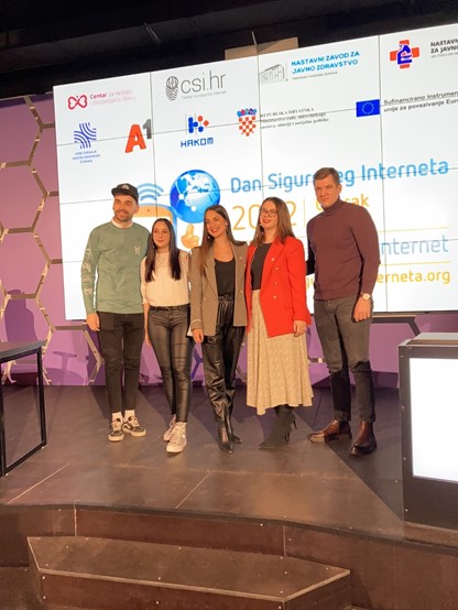 People standing in front of the Safer Internet Day Logo