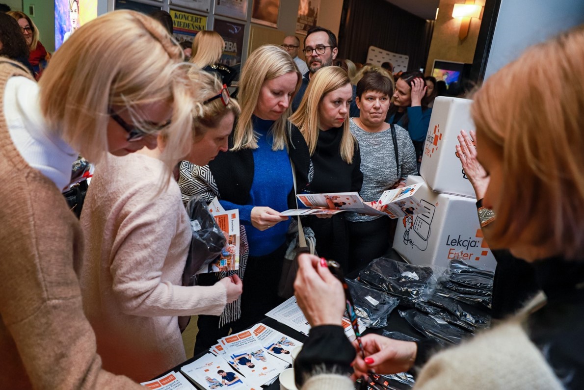 A group of visitors during the SID2023 main event in Poland, looking at leaflets at a stand and talking to SIC representatives. Credits: Polish SIC