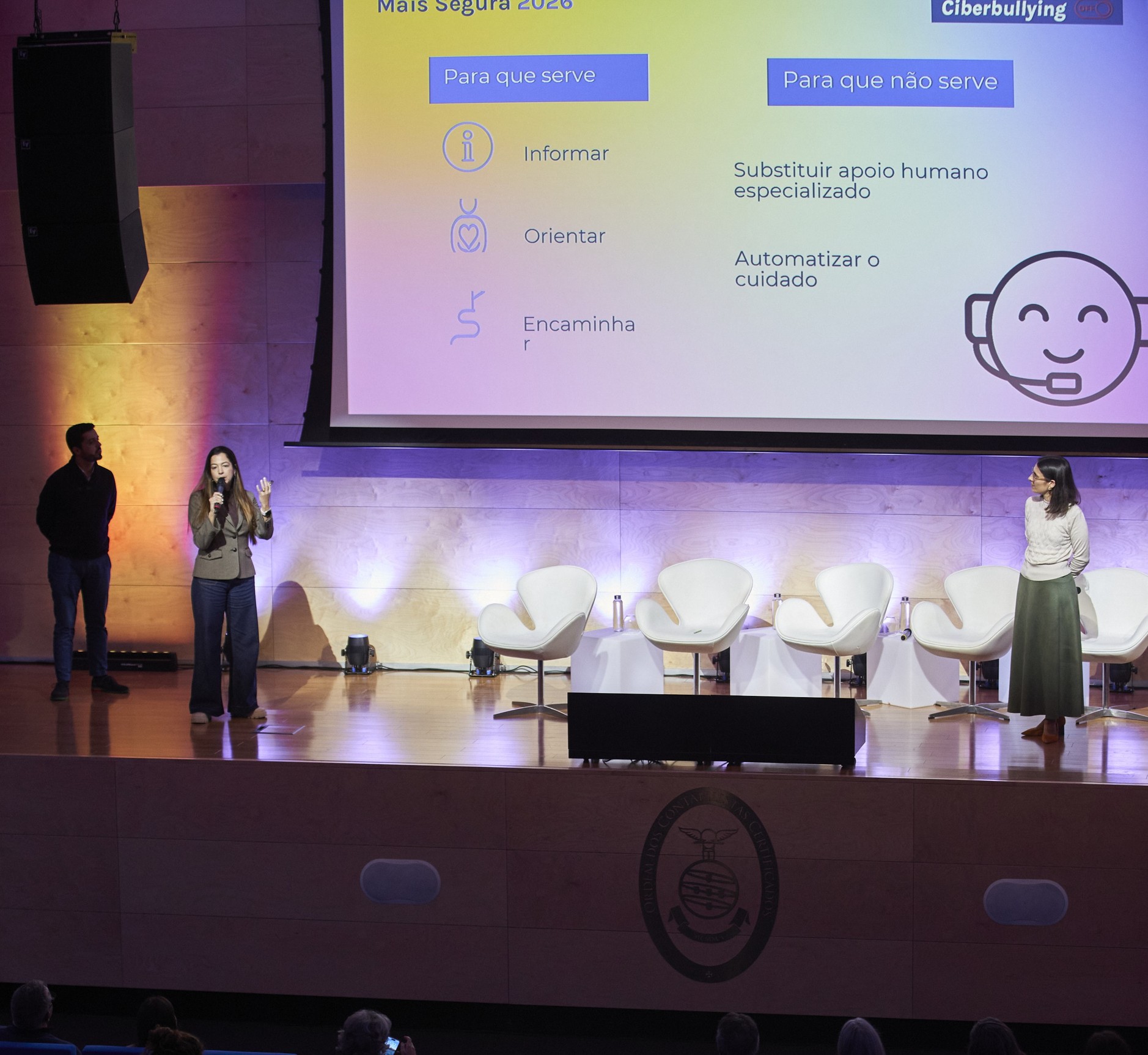 Three speakers on stage presenting the new chatbot