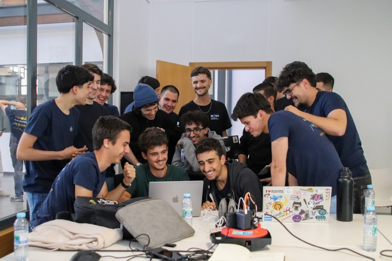 A group of young people using laptops and smiling at the bootcamp