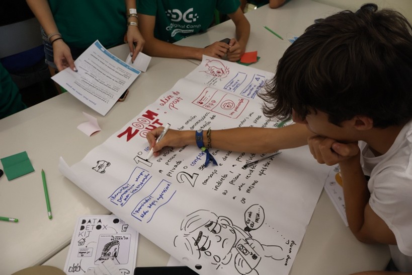 A young boy drawing on a large piece of paper