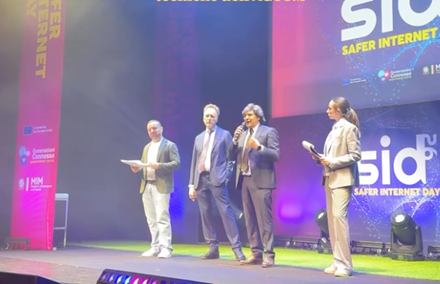 Stage with four speakers delivering a speech