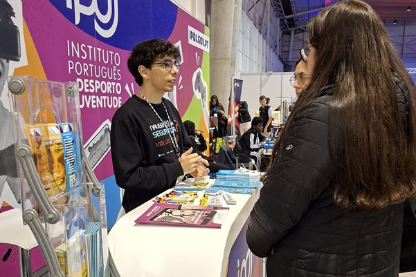 A staff member showing some educational materials to a passerby at the fair