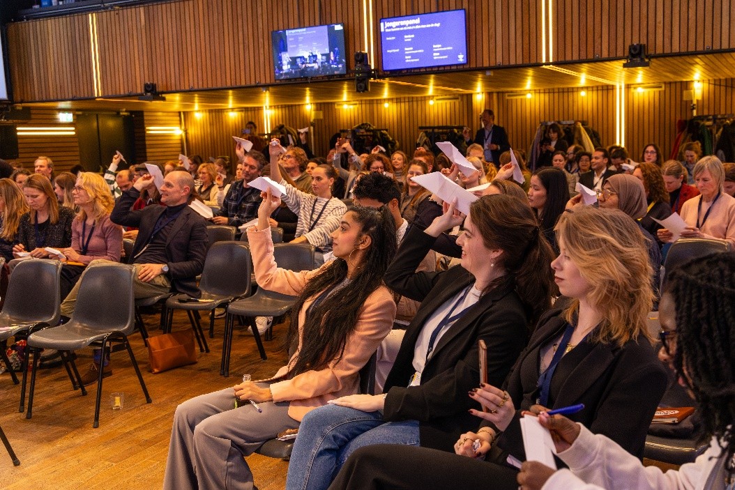 View of the public attending the high-level SID event in the Netherlands. They are all holding paper airplanes.