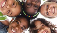 Children from different ethnicities hugging and smiling.