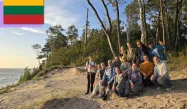 Group picture of all the camp participants on a beach at sunset