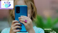 A young girl using a blue smartphone