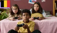 Two young girls and a young boy playing videogames and holding controllers