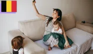 Mother taking selfie with toddler child on a sofa