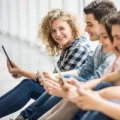 Young people sitting on the floor with digital devices