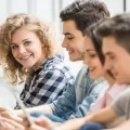 Young people sitting on the floor with digital devices