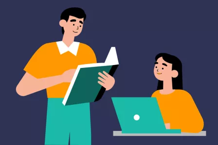 A teacher holding a book and a female student using a laptop
