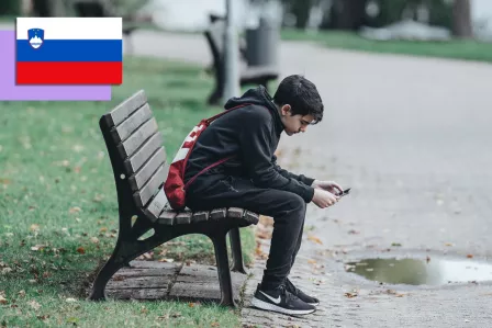 Boy sitting on a bench using his phone