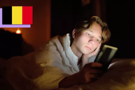 Teenager on their phone in the dark.