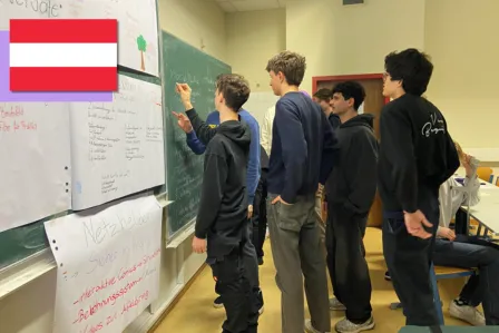 A group of young teenagers writing on a blackboard