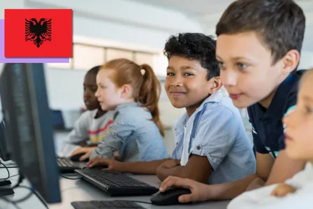 A group of five school mates looking at computer screens and using a mouse