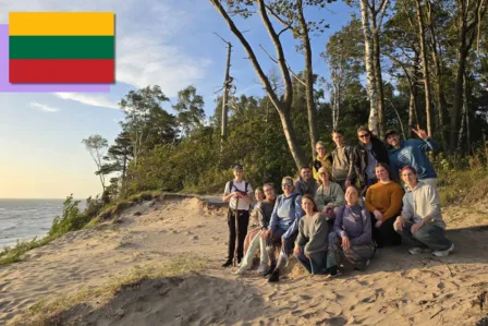 Group picture of all the camp participants on a beach at sunset