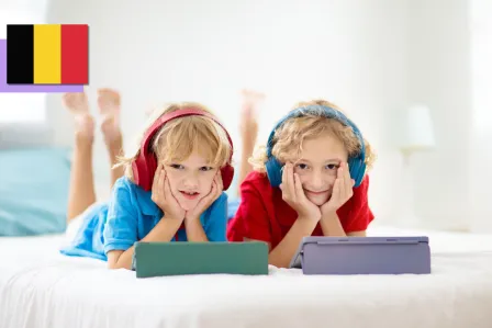 Two young boys with headphones on and tablets in front of them