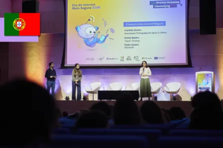 Three speakers on stage in front of a screen presenting the creation of Portugal’s Linha Internet Segura (LIS) chatbot.
