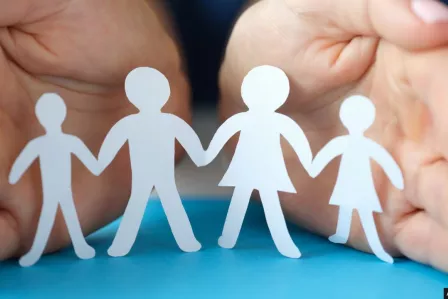 Women hands protecting a family with children from paper