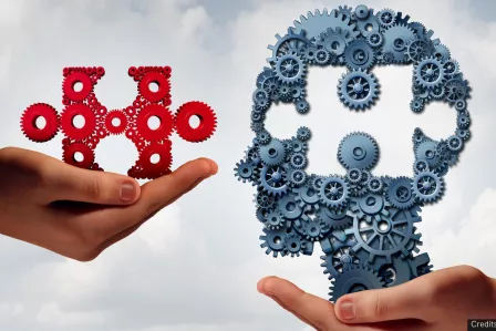 Two hands holding a piece of a puzzle and the figure of a head missing a space the size of the puzzle piece
