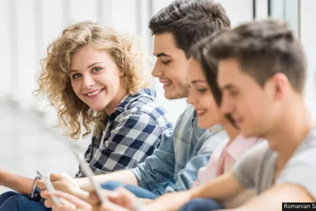 Young people sitting on the floor with digital devices