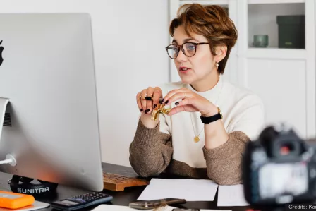 Woman sitting at a desk and presenting at an online webinar