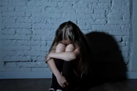 Lonely, upset child in a dark, sinister setting