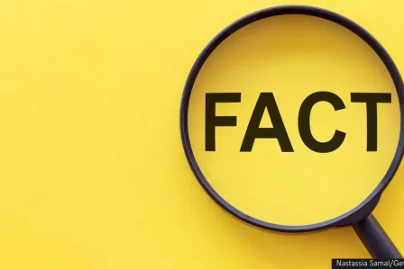 Fact - word through magnifying glass on a yellow background