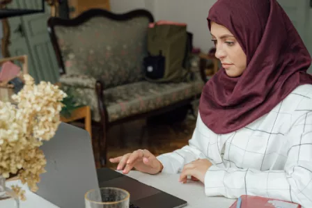 Young woman sitting at a desk and using a laptop