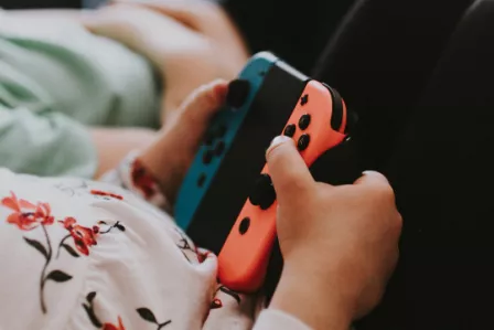 Close up image of a child's hands holding a gaming device