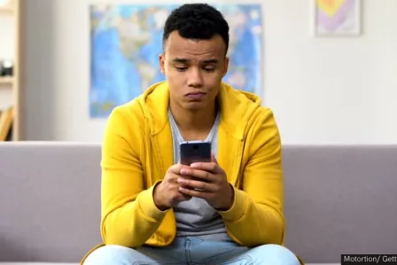 Teenager scrolling on his phone
