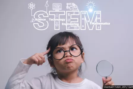Girl with glasses holding a magnifying glass