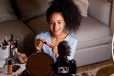 Teenage girl applying makeup in front of a mirror