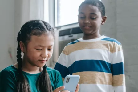Two children playing with a smartphone
