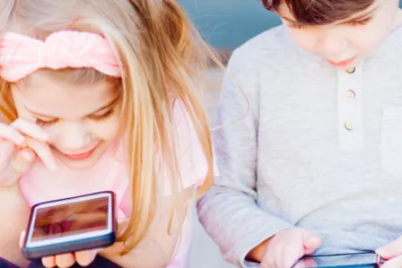 Young boy and girl using mobile devices
