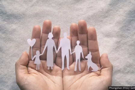 hand holding family made of paper