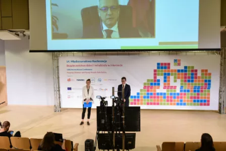 Two people standing in front of a camera during an online conference