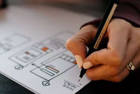Person mapping out user goals with a pen and paper