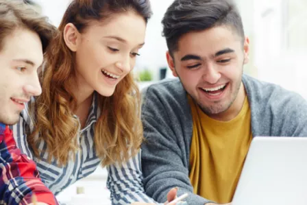 Three smiling teens, using a tablet together