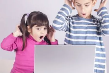 Children watching a screen with surprise