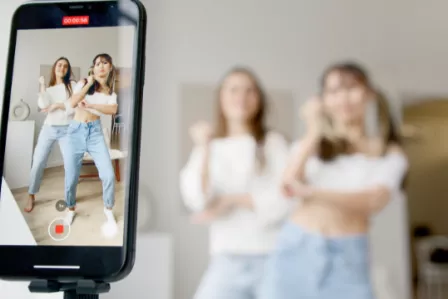 Two girls dancing on a video capture on a mobile device
