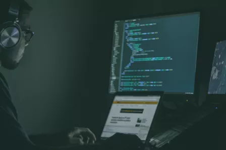 Hacker looking at code on a screen