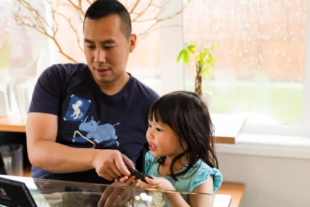 Father and young daughter using a tablet device