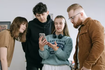 Four young people looking at a smartphone