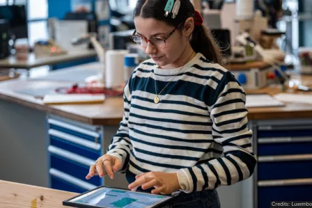 A young girl working on a tablet at the SID event in Luxembourg