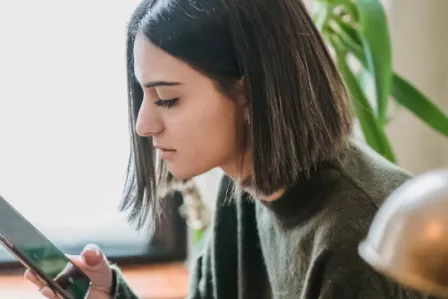 A girl scrolling through her smartphone at home
