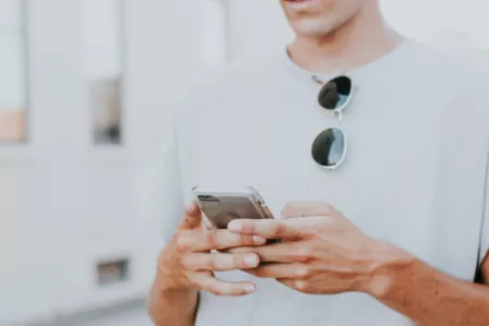 Torso of a man using a mobile phone